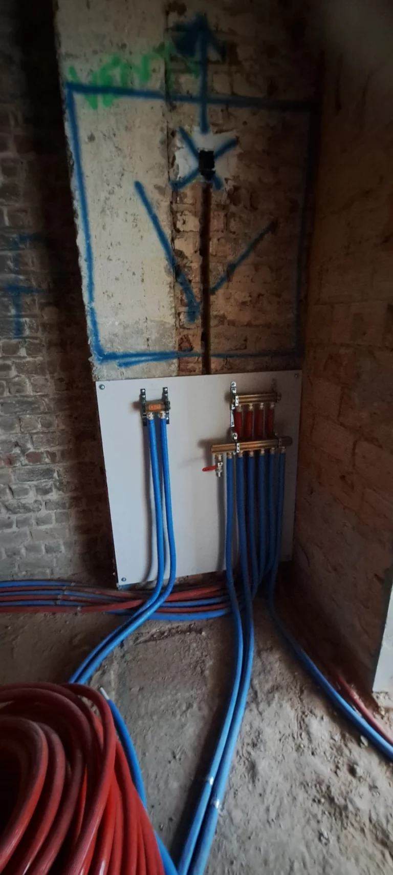 Verdeler voor vloerverwarming tegen de bestaande bakstenen muur