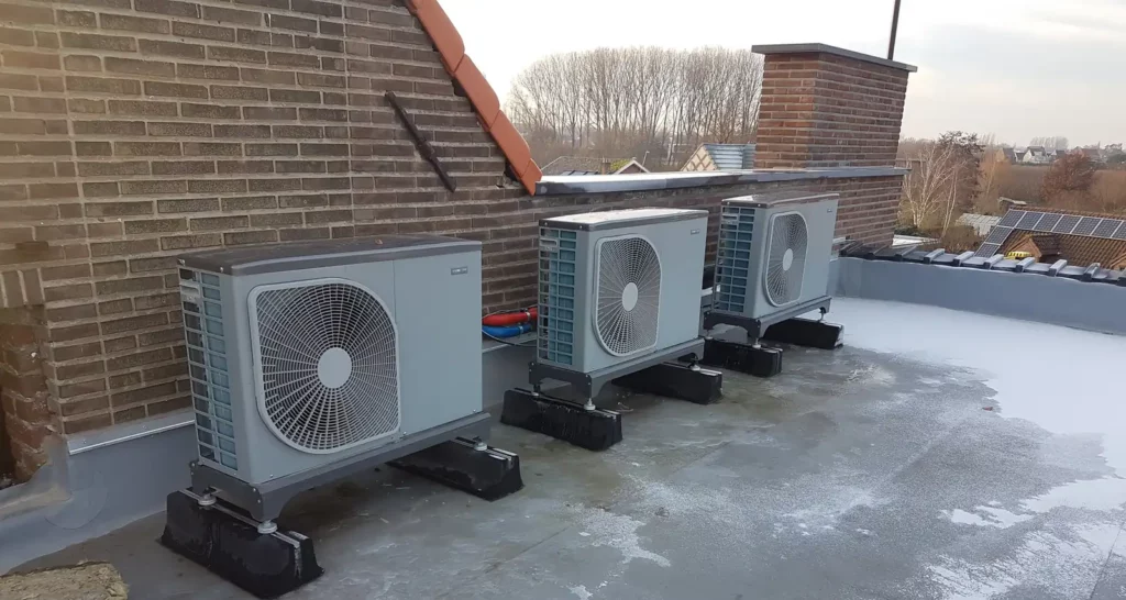 Buitenunits van de warmtepompen naast elkaar opgesteld op het platte dak